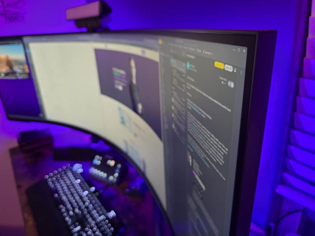 Curved computer monitor in a dimly lit room.