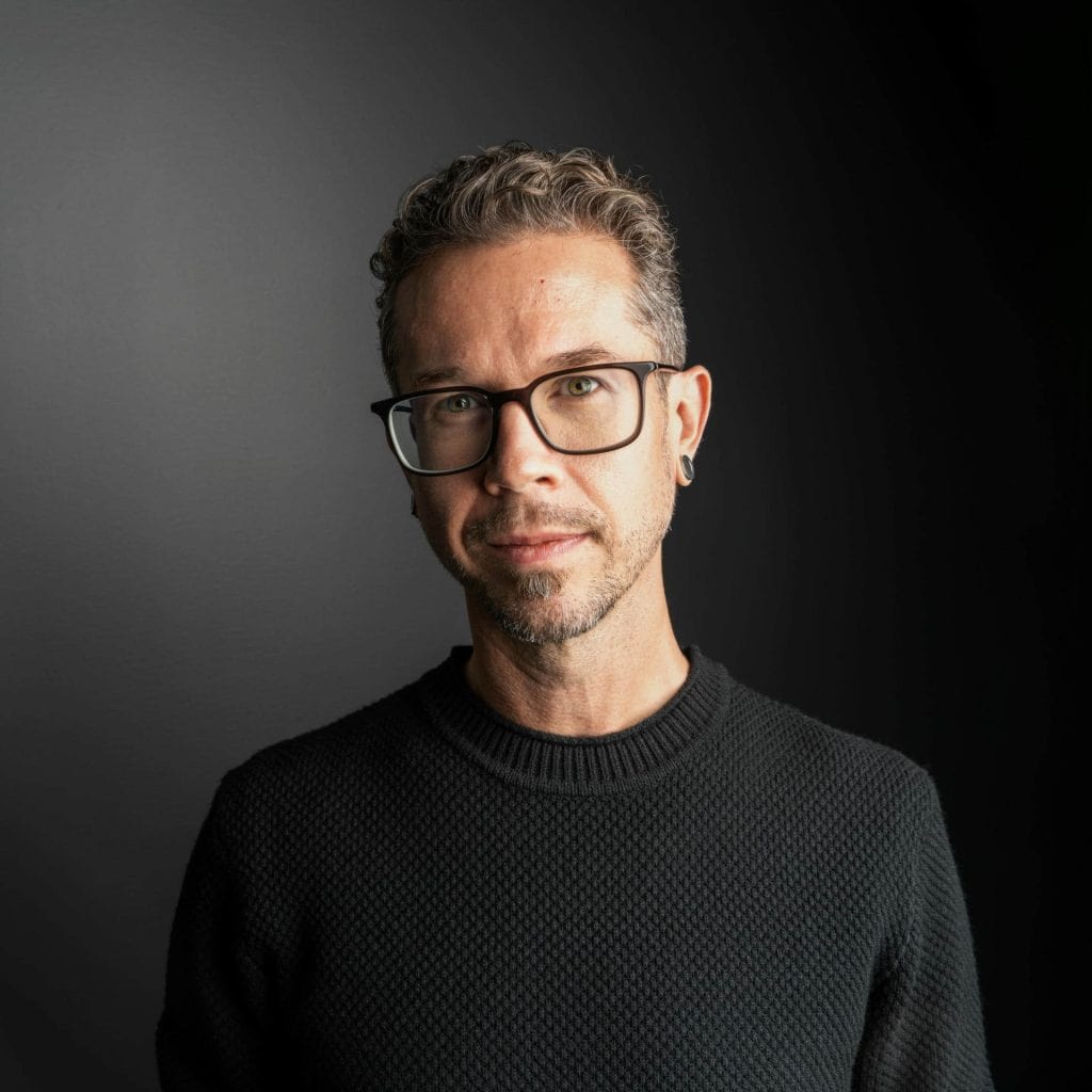 Anthony Richter headshot with glasses in a dark sweater.